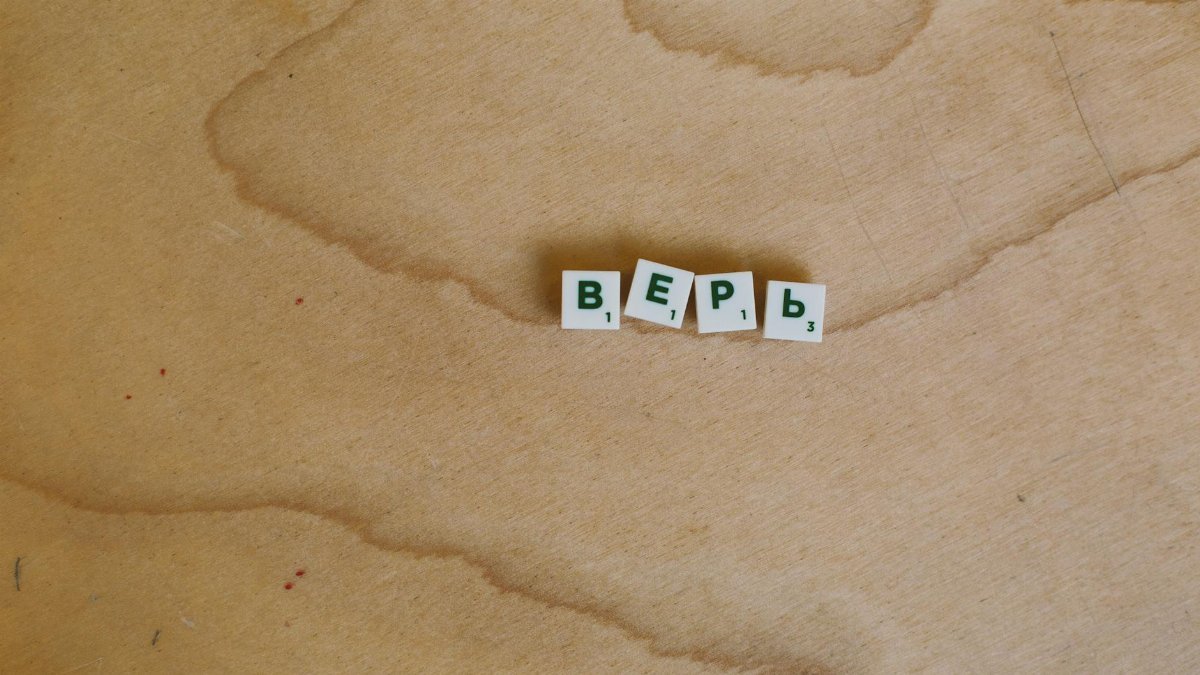 Scrabble tiles with Cyrillic letters spelling 'верь' displayed on a wooden surface.