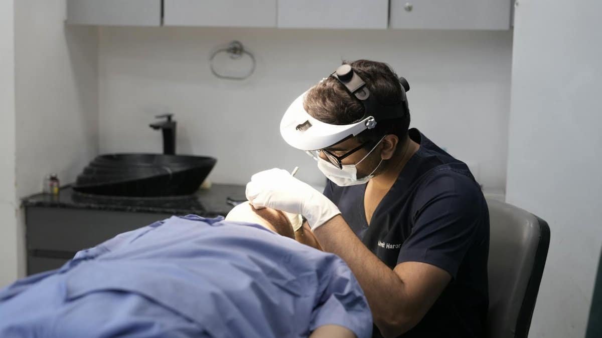 A dermatologist performing a procedure in a clinical setting in Delhi, India.