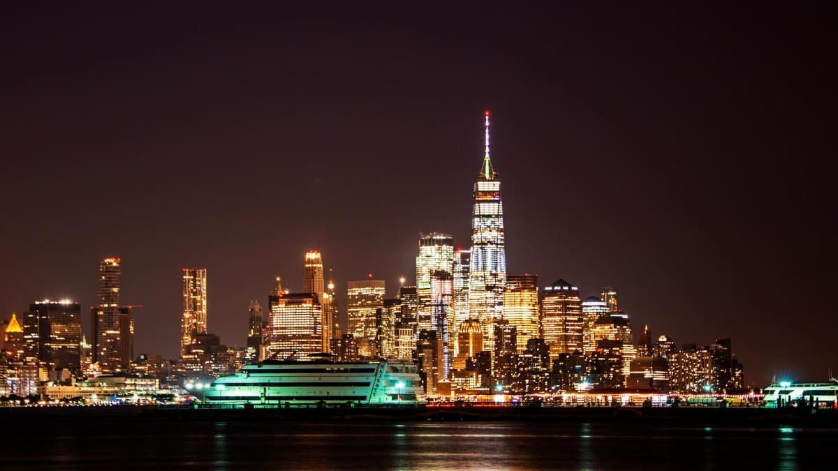 Dazzling New York City skyline with One World Trade Center illuminated at night.