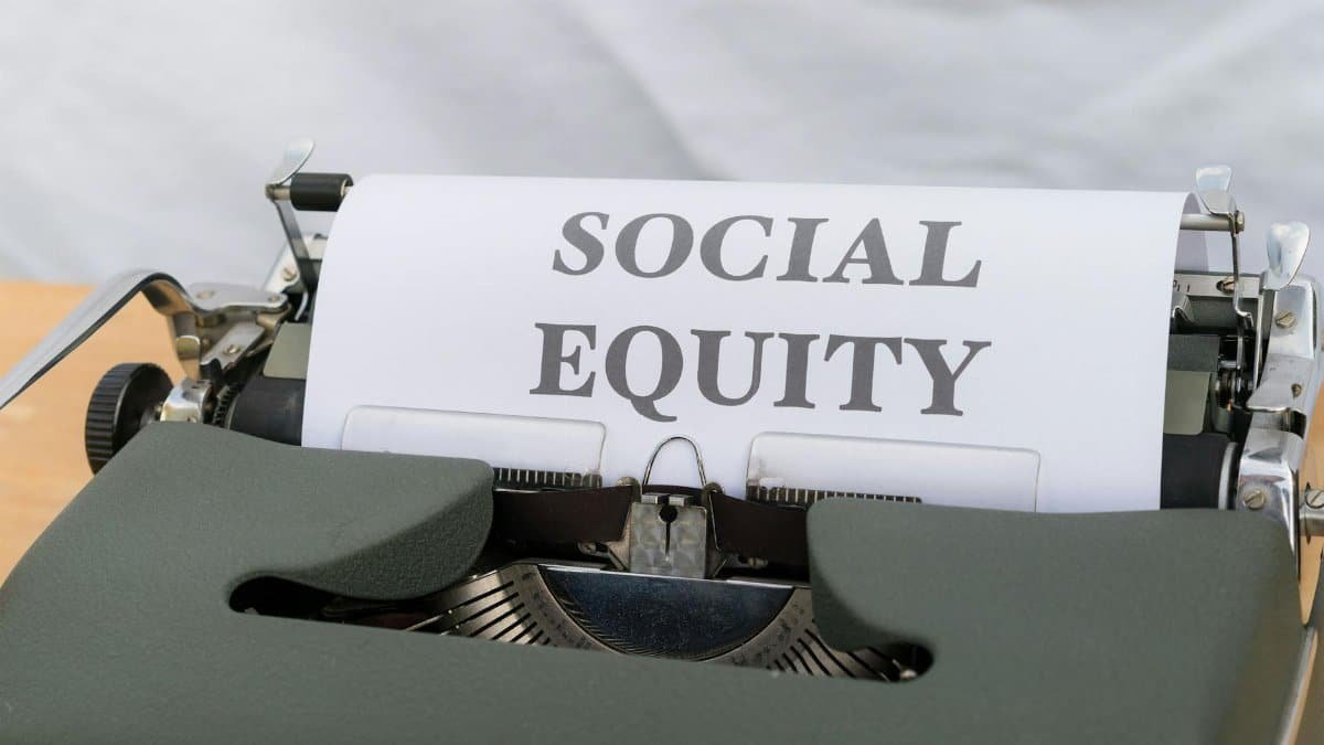 Close-up of a vintage typewriter displaying the message 'Social Equity' on paper.