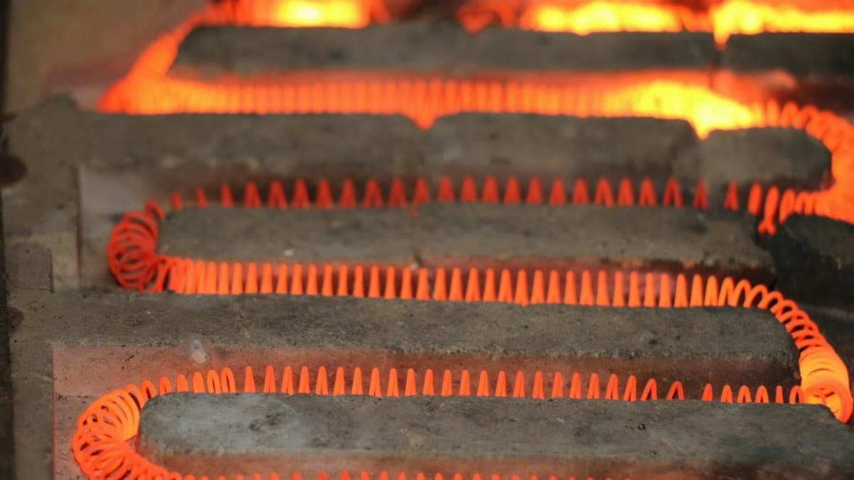 Detailed view of a glowing electric heating element with a coiled structure emitting heat.