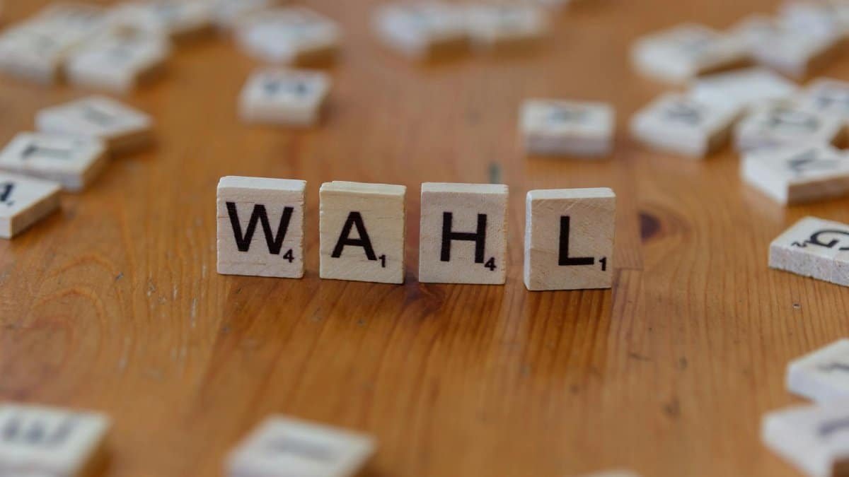 Scrabble letter tiles forming 'WAHL' on a wooden table, close-up view.