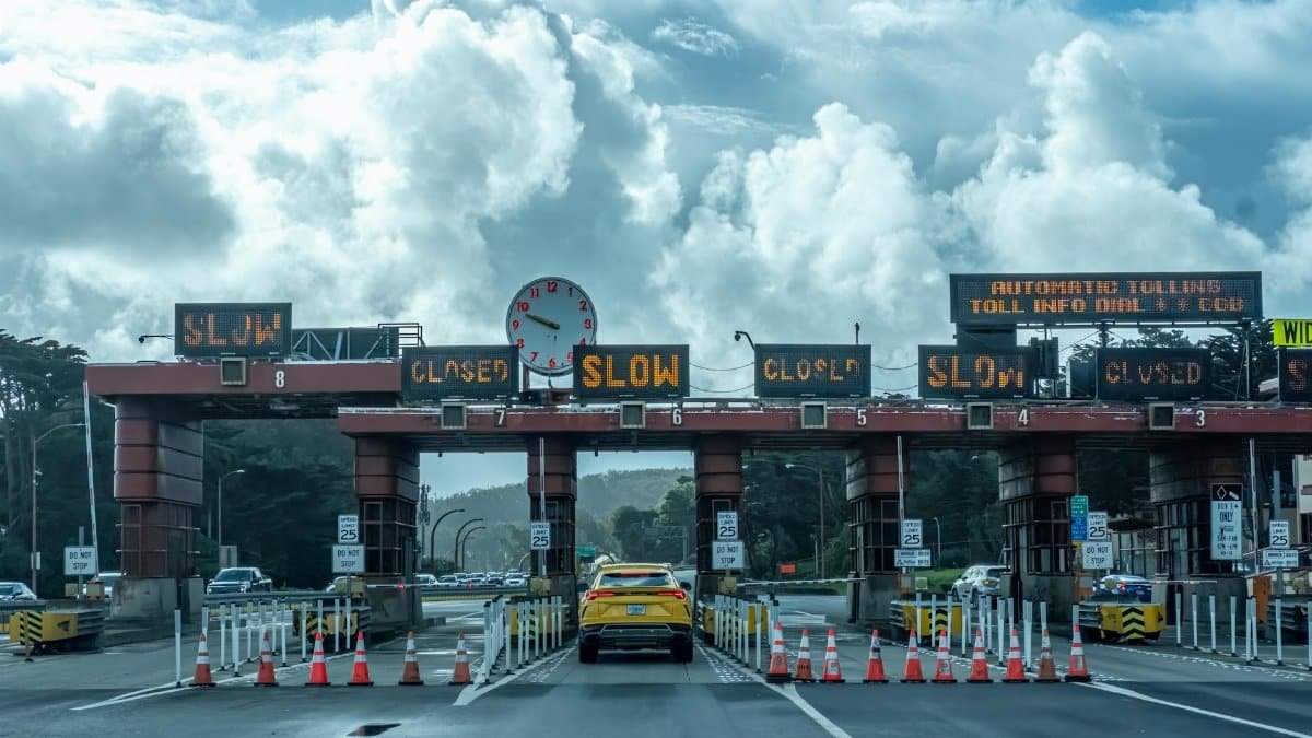 View of vehicles approaching the toll plaza at Golden Gate Bridge in San Francisco under a cloudy sky.