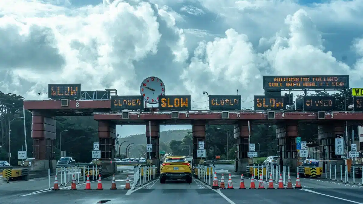 View of vehicles approaching the toll plaza at Golden Gate Bridge in San Francisco under a cloudy sky.