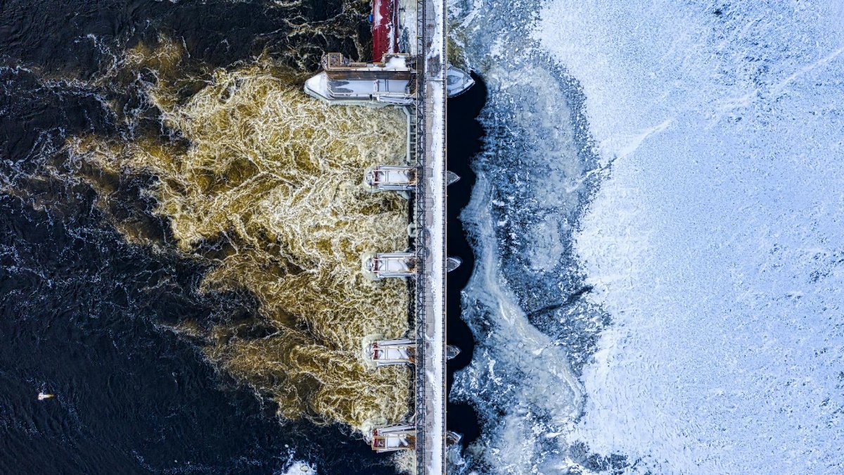 Drone shot of a bridge over a partially frozen river in Minnesota during winter.