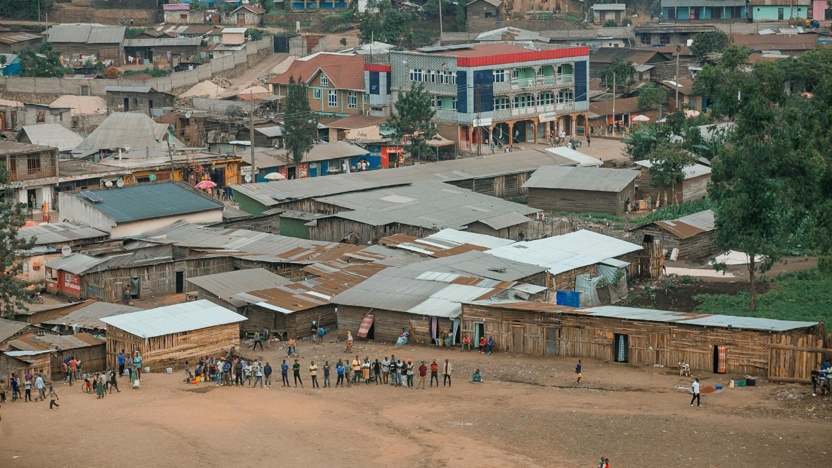 Aerial view of a lively community scene in an African town with colorful buildings.