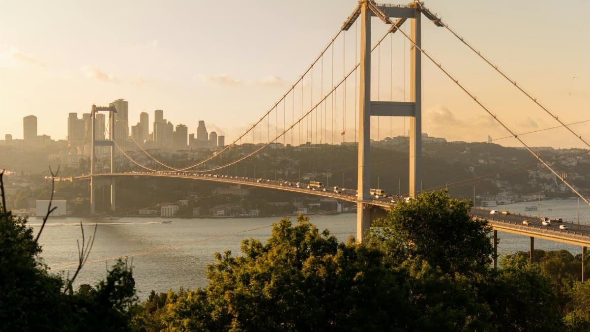 Scenic view of the Bosphorus Bridge at sunset in Istanbul, with the city skyline as a backdrop.