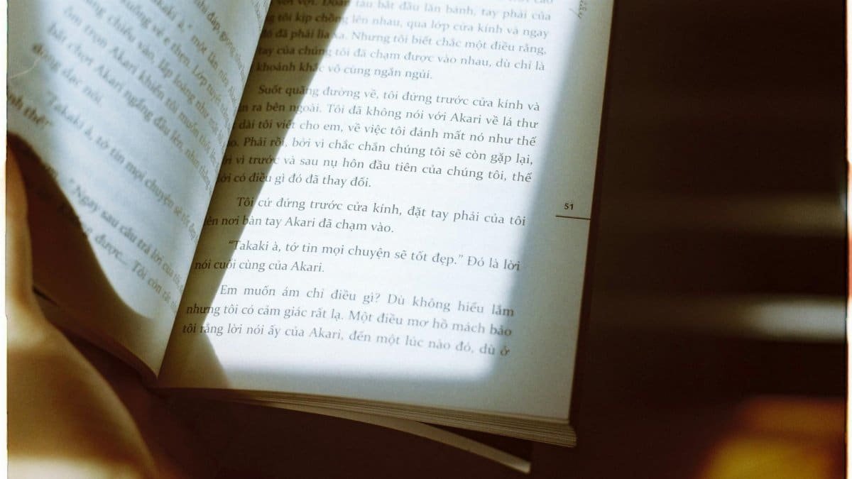 A book opened under warm sunlight, highlighting Vietnamese text.