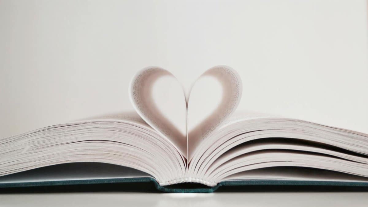 Close-up of open book with pages forming a heart shape, symbolizing love for reading.