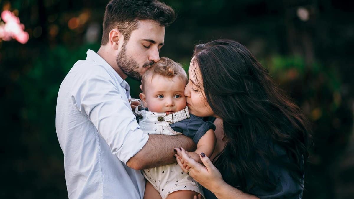 A heartwarming outdoor portrait of a loving family embracing their baby.