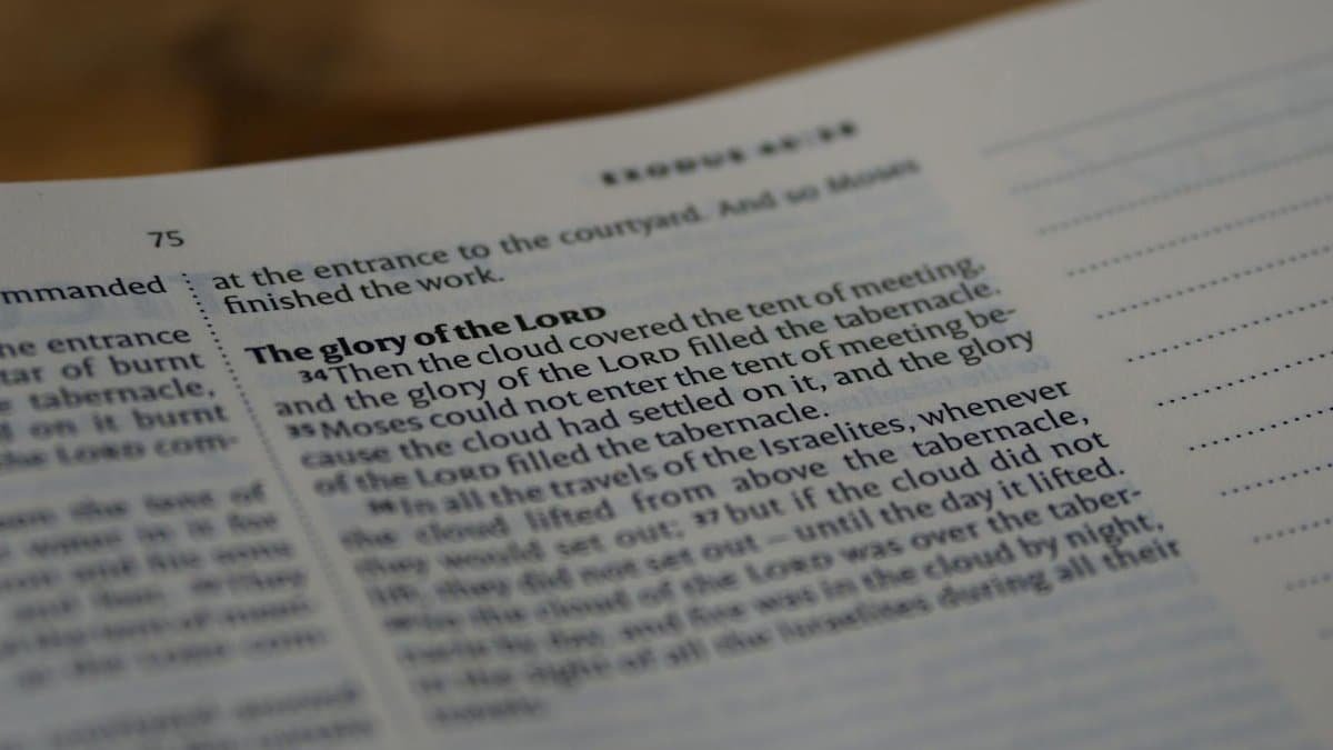 A focused close-up of a Bible page highlighting Exodus 40:34, depicting profound religious themes.