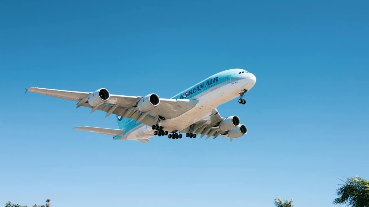 A large commercial aircraft in a clear blue sky during daytime landing approach.
