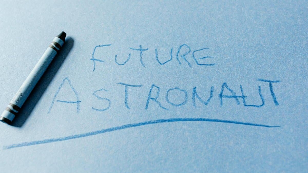 Handwritten text 'Future Astronaut' on blue paper with a crayon.