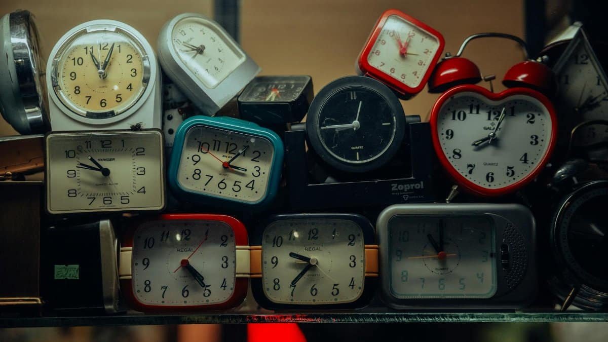 A collection of vintage alarm clocks stacked together, showcasing diverse designs and styles.