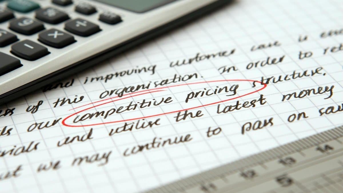 Focused image of handwritten business notes with calculator emphasizing pricing strategy.