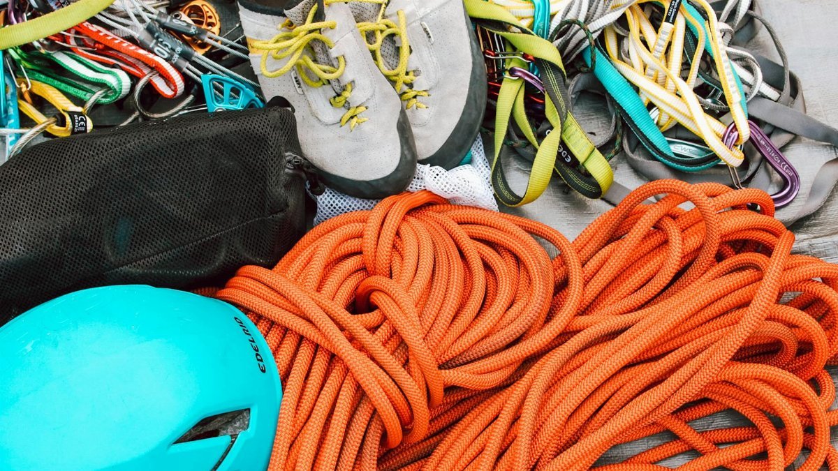 Close-up of mountain climbing gear including ropes, helmet, and harnesses for safety.