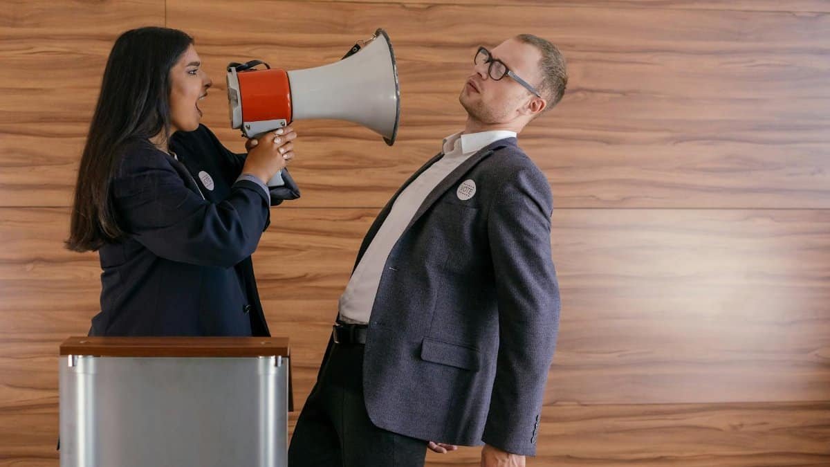 Dynamic image of two politicians arguing; one shouts into a megaphone in a heated debate.