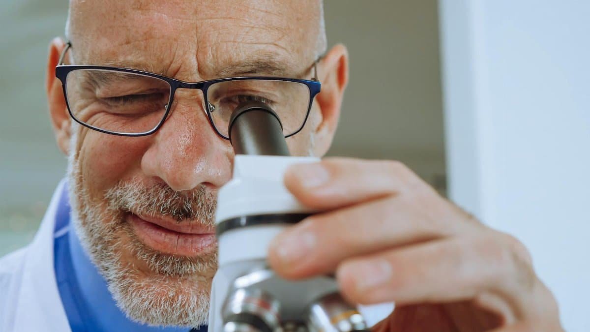 Close-up of a male scientist using a microscope in a laboratory.