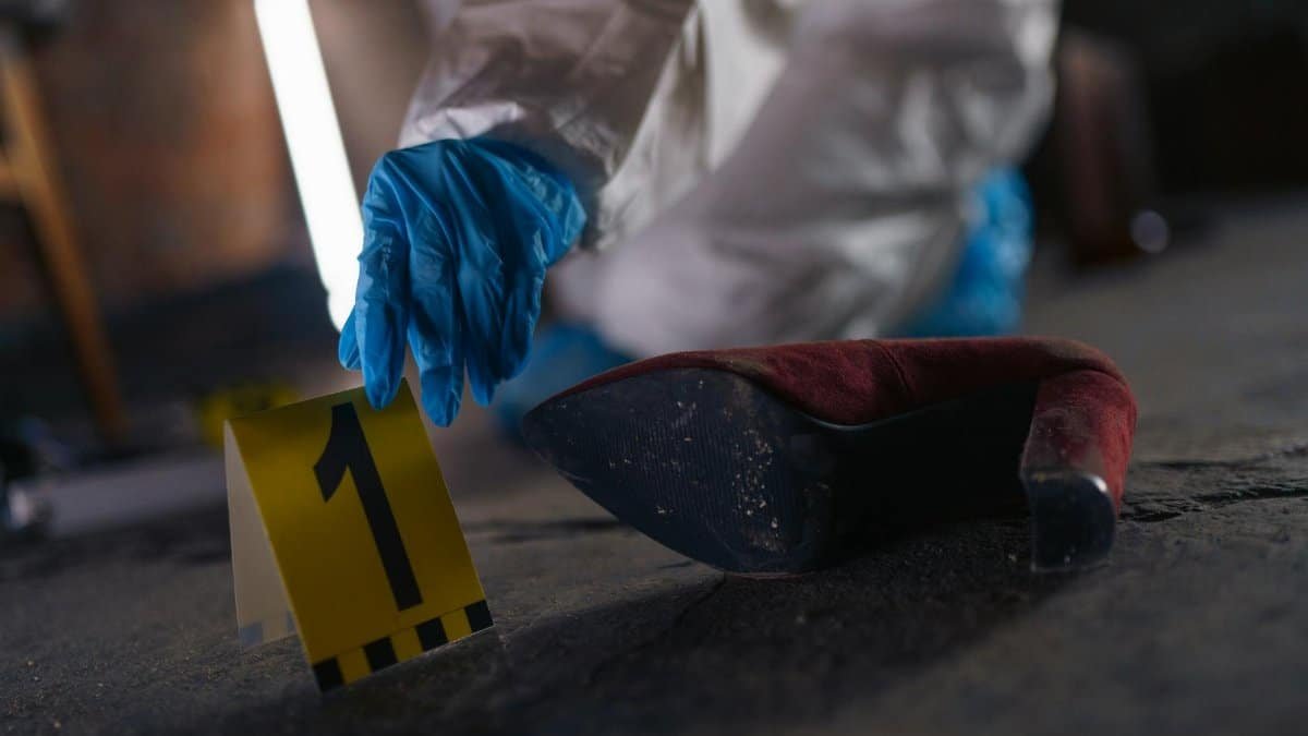 Crime scene investigation with shoe as evidence marked with number one and forensic glove.