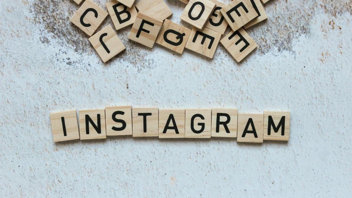 Wooden letter blocks arranged to spell 'Instagram' on a textured surface.