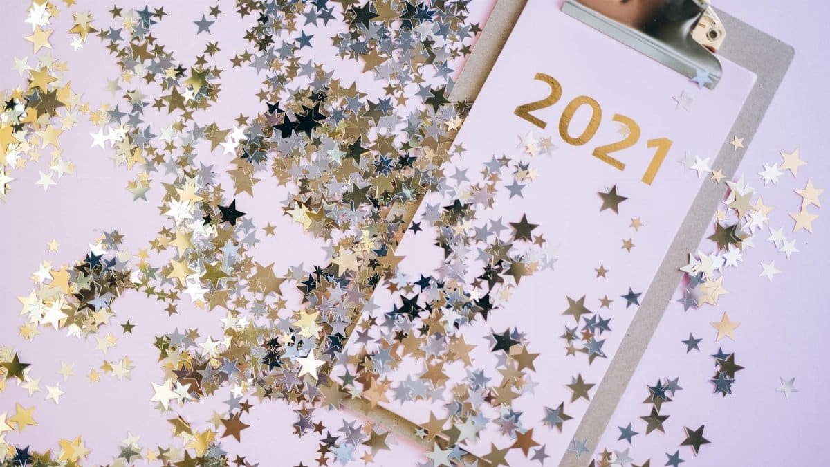 A festive New Year image with glitter stars on a 2021 clipboard, perfect for holiday decorations.
