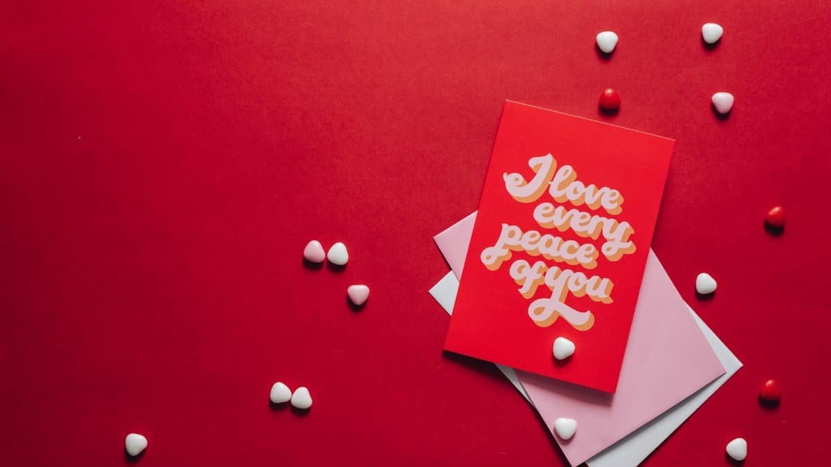 A valentine's card saying 'I love every piece of you' surrounded by heart shapes on a red background.