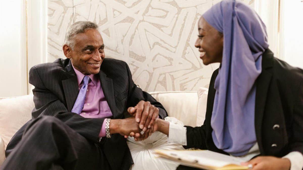 Professional interaction between diverse businesspeople shaking hands indoors.