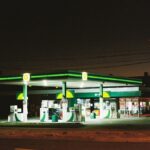 Illuminated BP gas station at night in Melbourne, showcasing urban life.