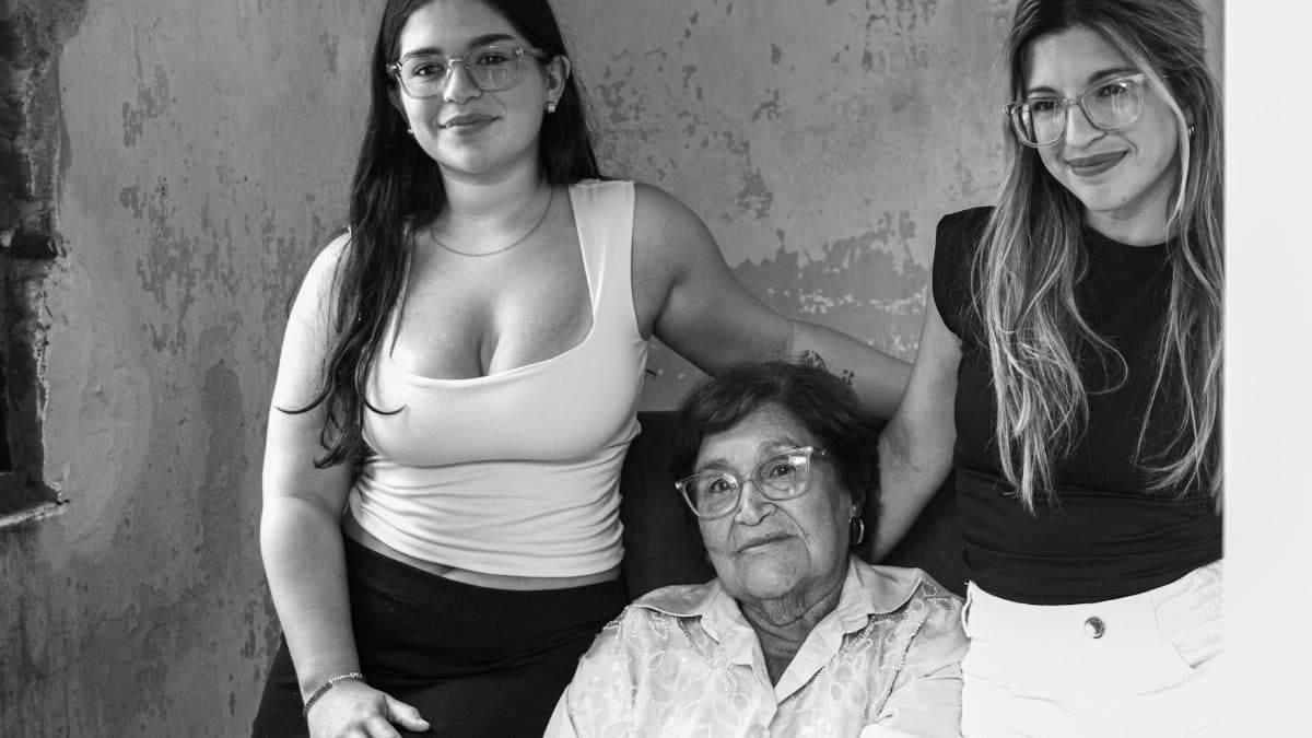 Candid black and white portrait showcasing three generations of women in a family setting.