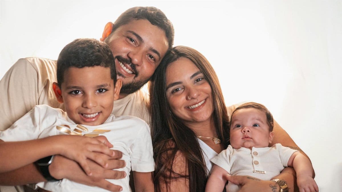 Joyful family portrait featuring smiling parents with their young children.