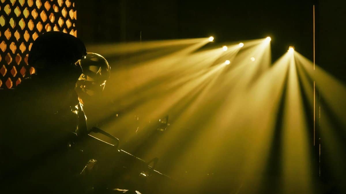 Silhouetted soldiers with dramatic beams of light in a military setting.