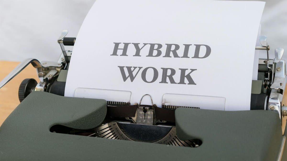 Close-up of a vintage typewriter with the text 'Hybrid Work' on paper, symbolizing modern work trends.