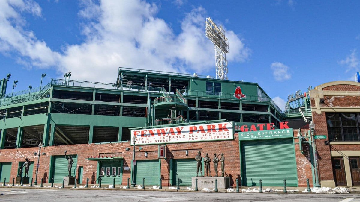 Iconic Fenway Park entrance on a clear day in Boston, showcasing historic architecture and vibrant atmosphere.
