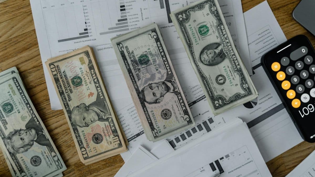A workspace setup featuring cash, documents, and a calculator symbolizing financial analysis and budgeting.