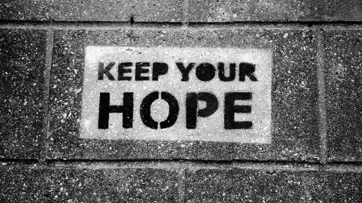 Black and white photo of 'Keep Your Hope' graffiti on a pavement.