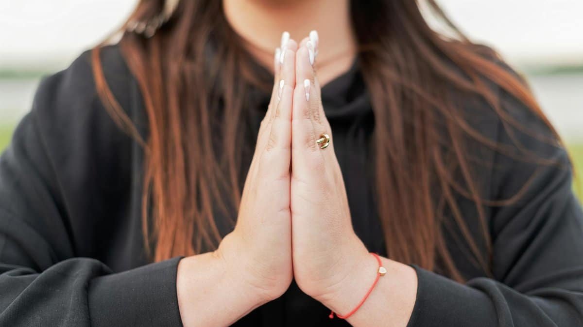 Close-up of a woman's hands in a prayer pose, symbolizing peace and mindfulness.