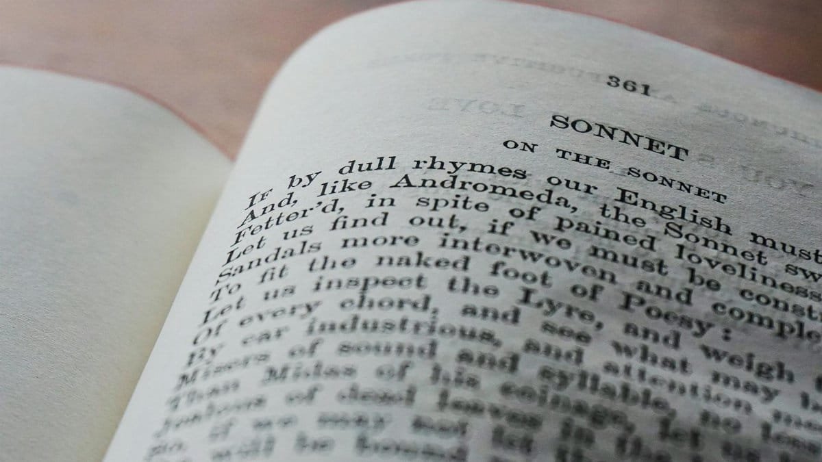 Close-up of an open book page displaying a classic English sonnet in black and white.