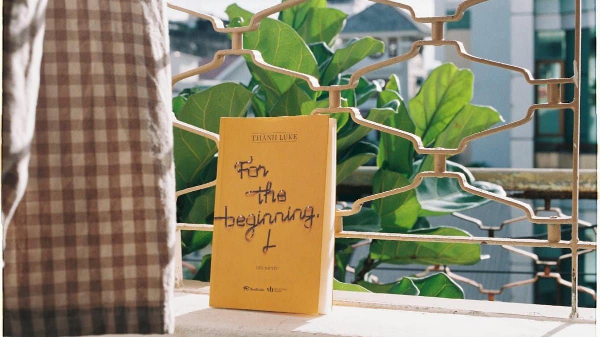 A yellow book titled 'For the Beginning' displayed on a balcony, captured with natural light.
