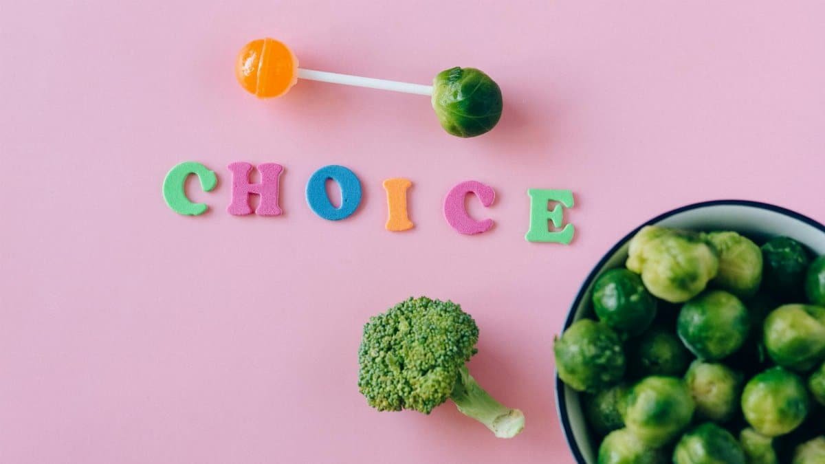 Colorful depiction of healthy and sweet food choices on pink backdrop.
