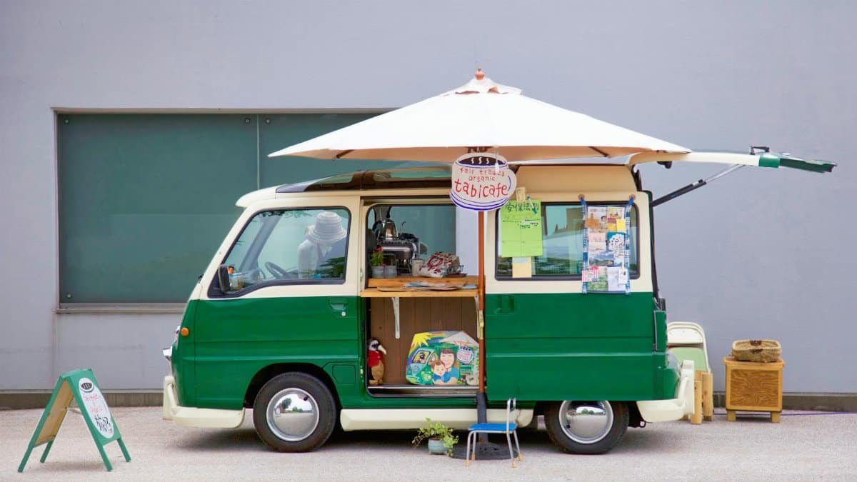 Colorful green food truck with umbrella, offering street food in Tokushima, Japan.