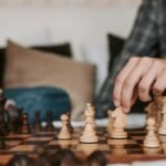 Two people play an intense chess game indoors, focusing intently on strategy.