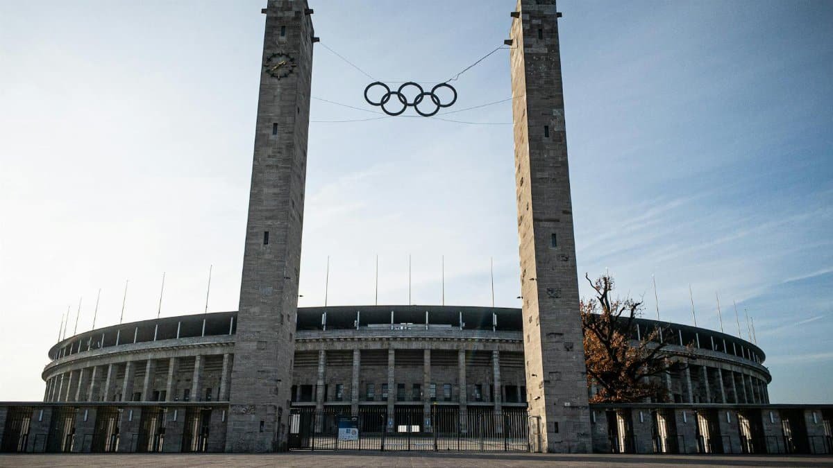 View of the Olympic Stadium in Berlin featuring the Olympic rings between two towers.