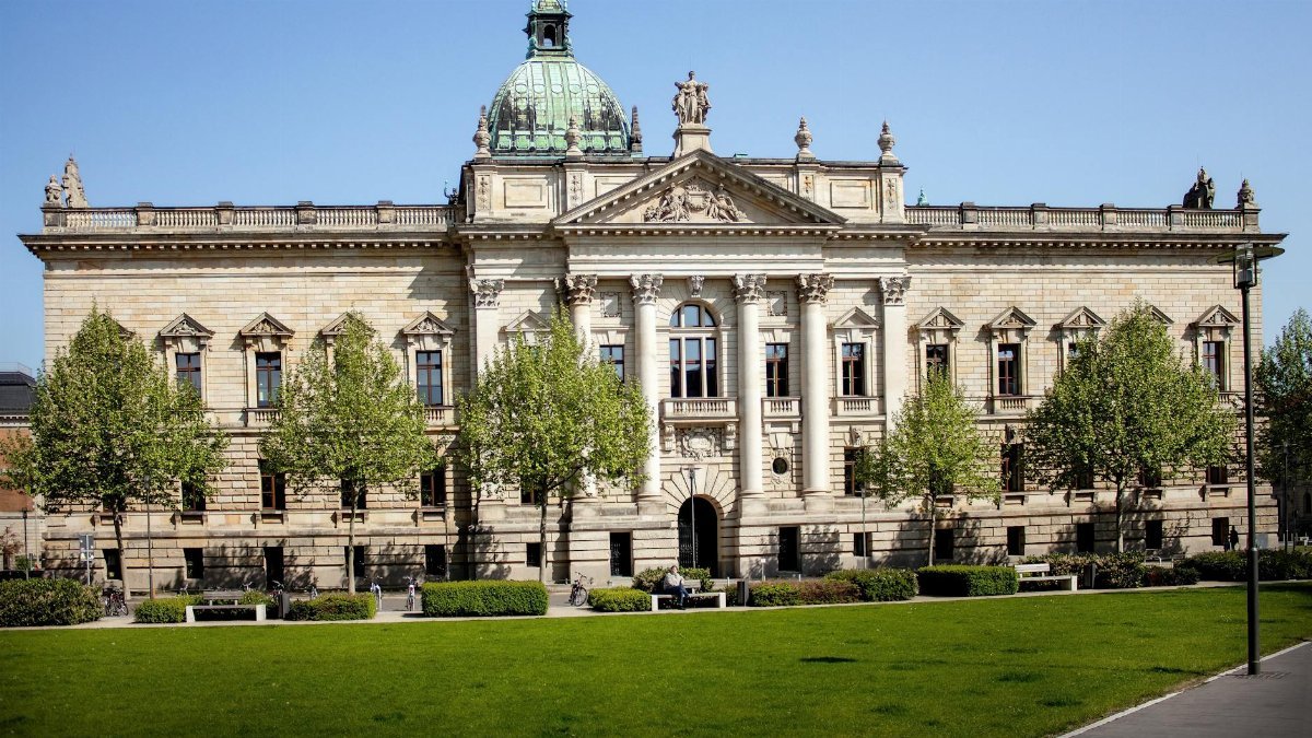 Front view of the Federal Administrative Court in Leipzig, Germany with a green lawn and clear sky.