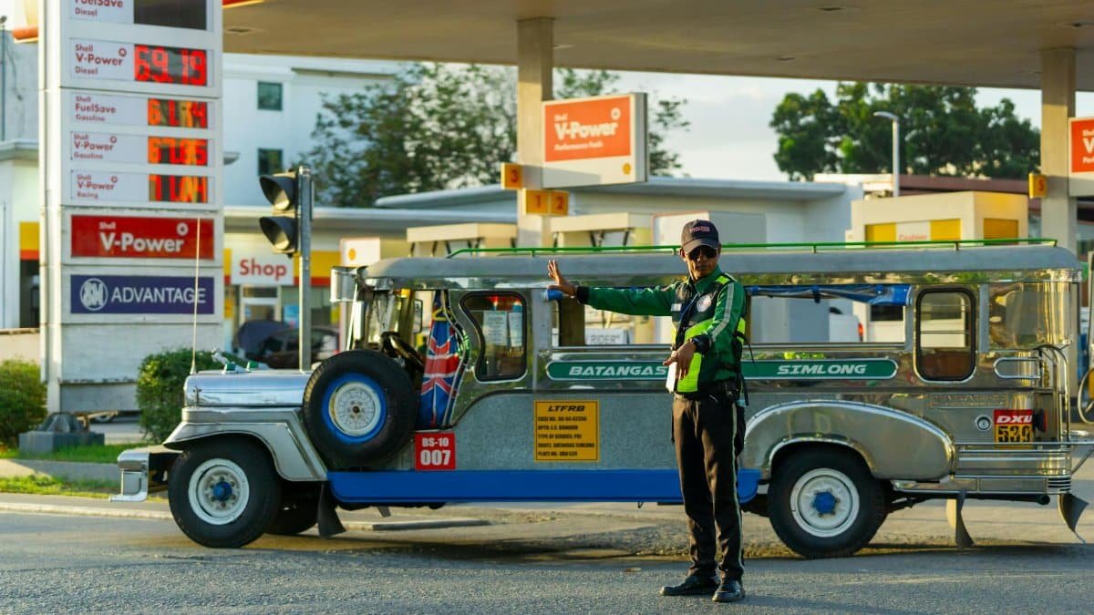 Traffic officer signals jeepney at a fuel station in the Philippines with clear weather and dynamic setting.