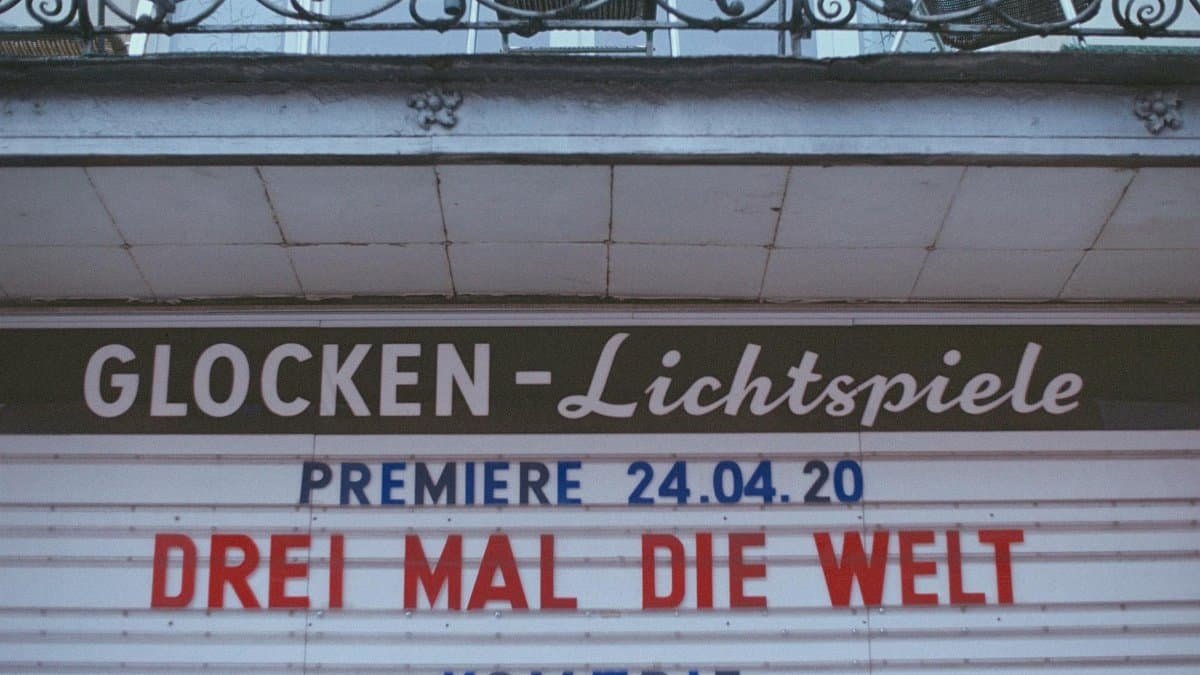 Retro cinema sign announcing 'Drei Mal Die Welt' premiere on April 24, 2020.