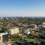 Aerial daytime view of Miami, Florida capturing city skyline and distant ocean.
