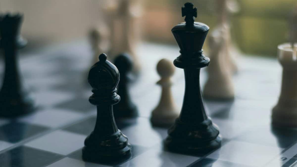 Close-up of chess pieces on a chessboard, emphasizing a strategic game setting.