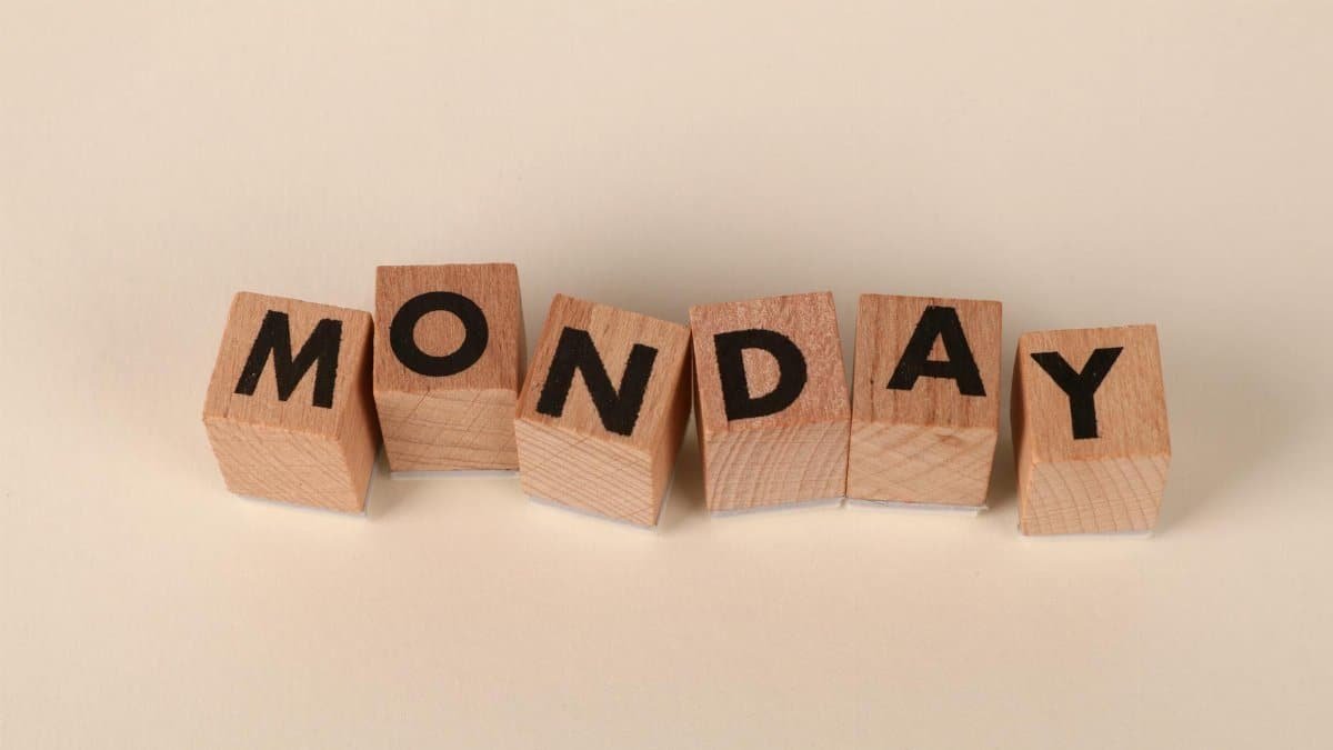 Wooden blocks spelling Monday on a neutral background, symbolic of the start of the week.