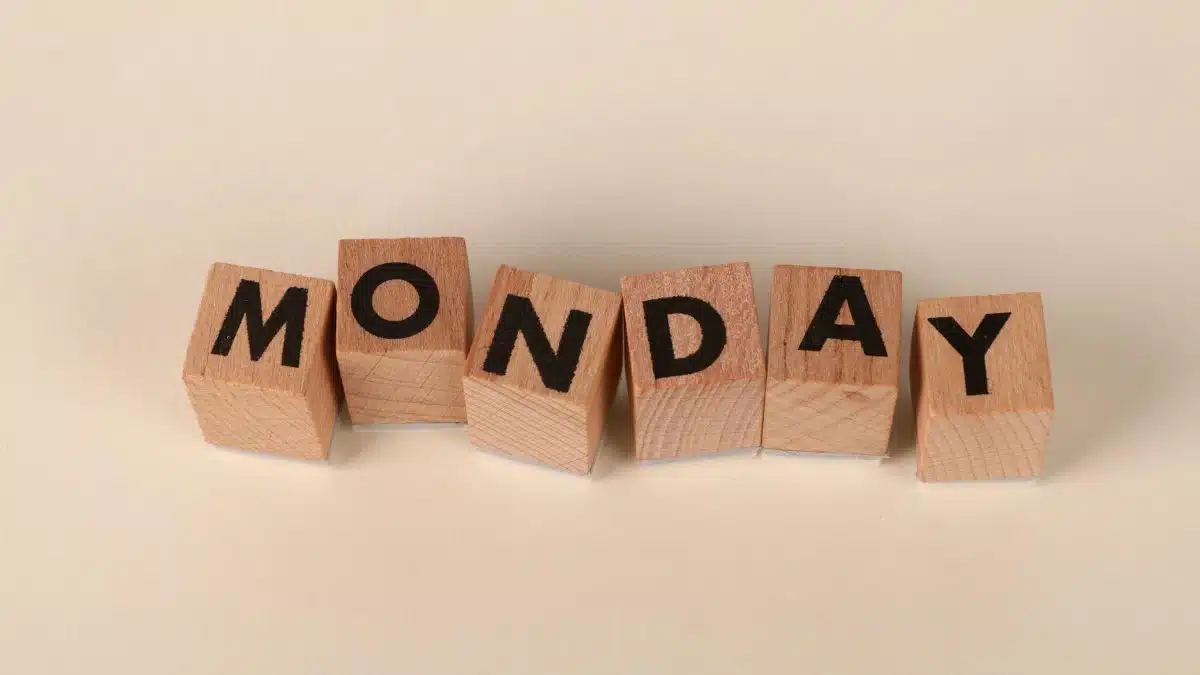 Wooden blocks spelling Monday on a neutral background, symbolic of the start of the week.