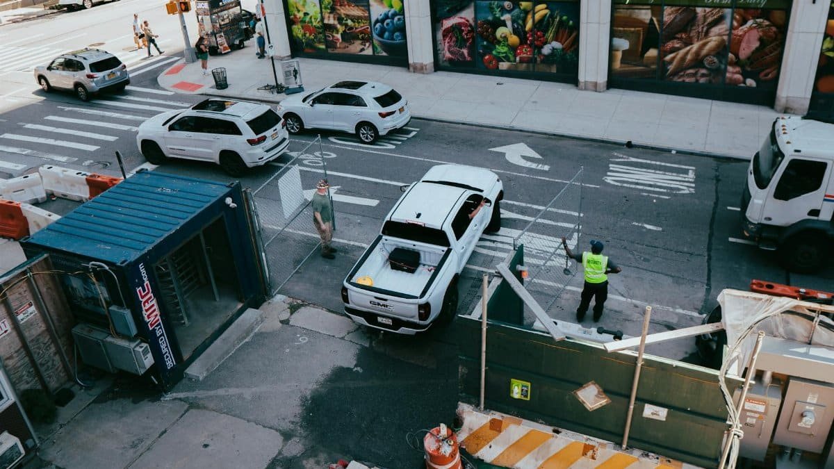 A busy urban street intersection in New York City featuring construction activity and ongoing traffic.